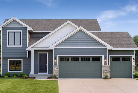 Exterior view of the Bennington split-level home featuring blue siding, white trim, and an attached multi-car garage.