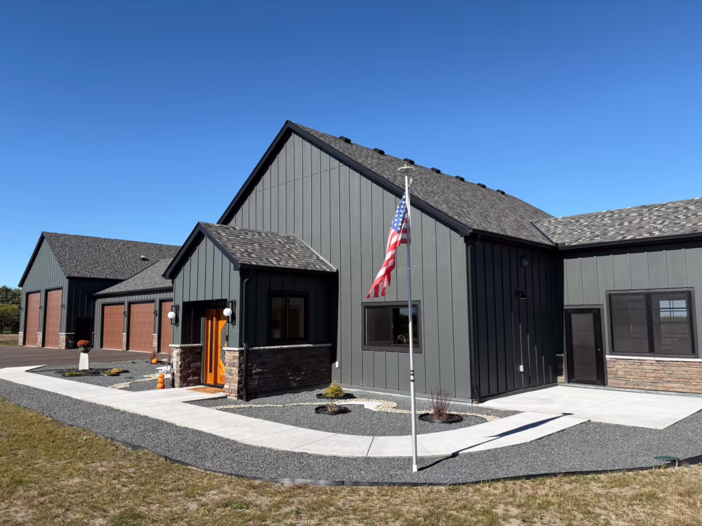 A beautifully designed, newly constructed custom home exterior featuring high-quality architectural details, a spacious front porch, large windows, and premium landscaping, showcasing expert craftsmanship and personalized home design.