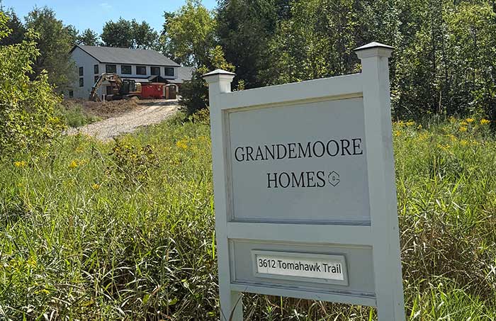 Grandemoore Homes custom home builder job site yard sign posted in front of a residential property.